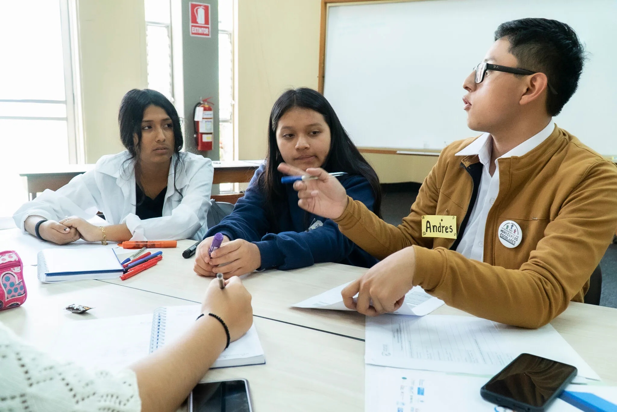 Adolescentes conversan alrededor de una mesa durante un taller.