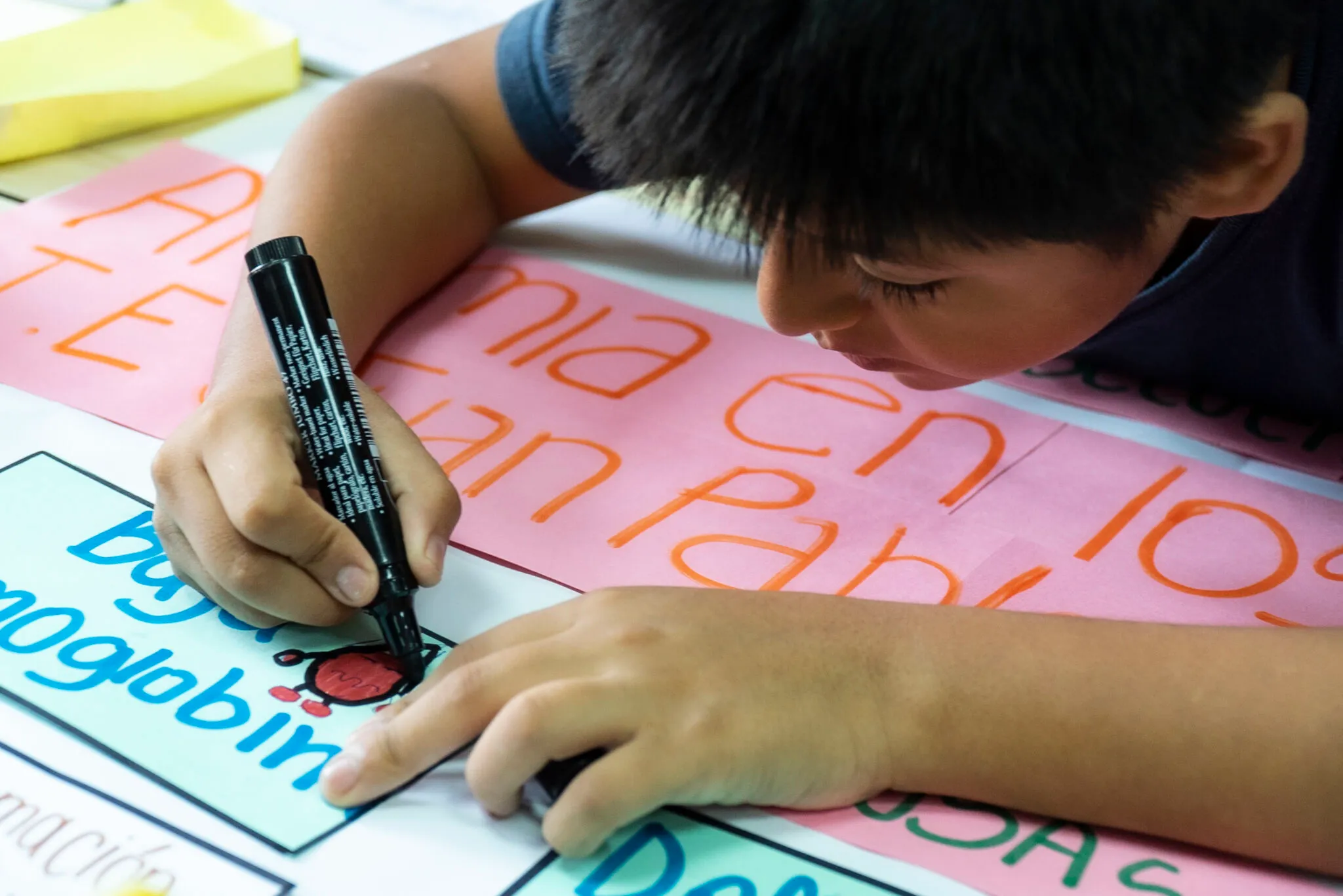 Un niño escribe sobre un papelógrafo durante una actividad de análisis.